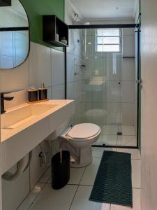 a bathroom with a toilet and a glass shower at Apê 302 prox ao SESC in Franca