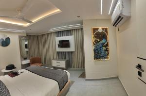 a bedroom with a bed and a chair in it at Hotel Red Rose in Vadodara
