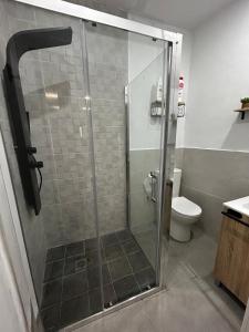 a shower stall in a bathroom with a toilet at MariaValiente in Montoro
