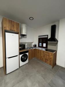 a kitchen with a white refrigerator and wooden cabinets at MariaValiente in Montoro