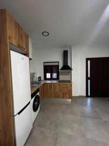 a kitchen with a white refrigerator and wooden cabinets at MariaValiente in Montoro +5 photos