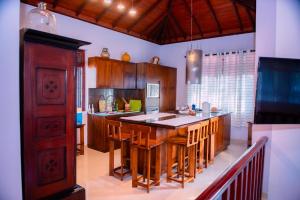 a kitchen with a large island with wooden cabinets at Sella Villa-Transit Airport in Seeduwa