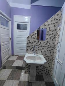 a bathroom with a sink and purple walls at moon guest house in Aswan