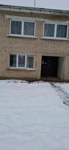 a brick house with a garage in the snow at Pas Dianą 1 aukštas in Jurbarkas