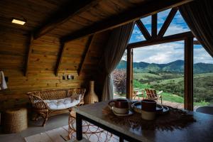 a room with a table and a large window at Olivas Eco Chalé in Pouso Alto