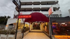 a restaurant with a red sign in front of a building at Sürücü oteli in Milas