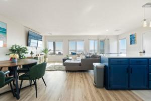 a kitchen and living room with blue cabinets and a table at Crescent Beach Motel in Crescent City