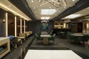 a dining room with tables and green chairs at Hotel TOS Residency Jubilee hills in Hyderabad