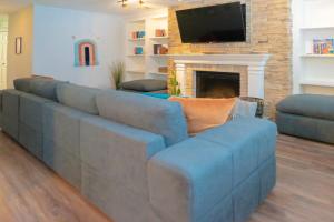 a living room with a blue couch and a fireplace at Lovely CWE 2BR with Private Parking ABODEbucks in Saint Louis
