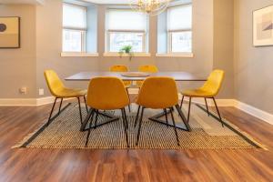 a dining room with a table and yellow chairs at Lovely CWE 2BR with Private Parking ABODEbucks in Saint Louis