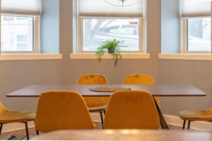 a meeting room with a table and yellow chairs at Lovely CWE 2BR with Private Parking ABODEbucks in Saint Louis +30 photos