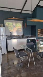 a kitchen with a table and chairs and a sink at Refúgio na Serra com Pôr do Sol in Feliz