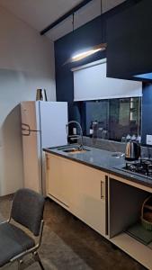 a kitchen with a refrigerator and a chair in it at Refúgio na Serra com Pôr do Sol in Feliz +17 photos