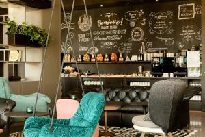 a restaurant with chairs and a wall with drawings on it at Motel One Barcelona-Ciutadella in Barcelona