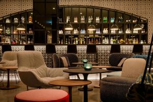 a bar with chairs and tables in a room at Motel One Barcelona-Ciutadella in Barcelona