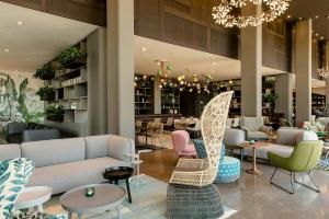 a lobby with couches and chairs and tables at Motel One Barcelona-Ciutadella in Barcelona