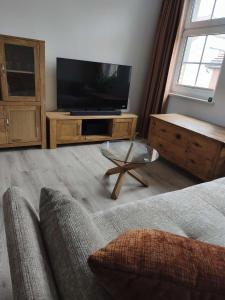 a living room with a couch and a television at Michas FeWo in Bautzen