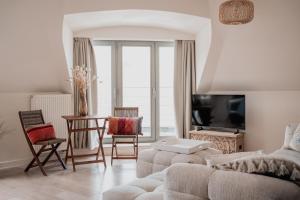 a living room with a couch and a table at Stylish downtown loft and opposite park in Maldegem