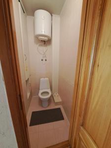 a small bathroom with a toilet and a light at Комнаты in Chişinău