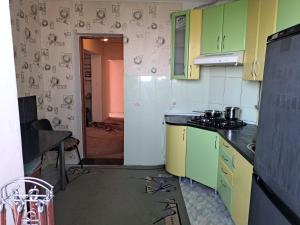 a kitchen with green and yellow cabinets in a room at Комнаты in Chişinău