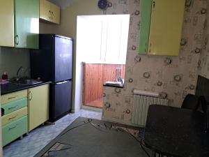 a kitchen with green cabinets and a sink and a window at Комнаты in Chişinău