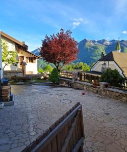 a stone patio with a fence and a tree at Cjase Cumine in Lauco