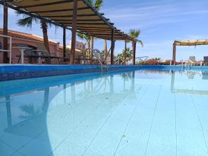 a large swimming pool with a blue tile floor at Club Cantamar Beach Hotel & Marina in La Paz