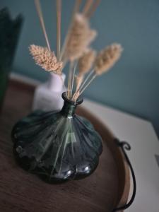 a black vase sitting on a table with feathers in it at Gästehaus Kampik in Witten
