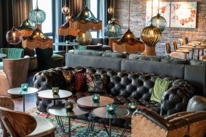 a restaurant with leather couches and tables and chairs at Motel One Berlin-Mitte in Berlin