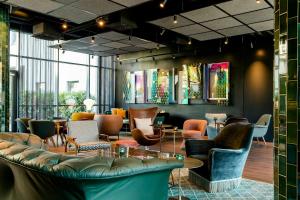 a lobby with chairs and tables in a building at Motel One Berlin-Hackescher Markt in Berlin