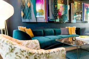 a living room with a blue couch and chairs at Motel One Berlin-Hackescher Markt in Berlin