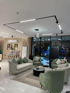 a living room with couches and chairs and a table at النخبة الرفيعة للشقق المخدومة in Al Qurayyat