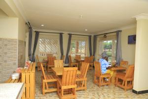 a person sitting at a table in a room with wooden chairs at Hakyiri B&B in Kabale
