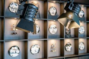 a room with masks on a wall with lights at Motel One Berlin-Ku'Damm in Berlin +41 photos