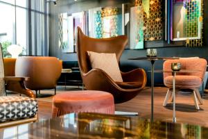 a lobby with chairs and a table in a room at Motel One Berlin-Hackescher Markt in Berlin