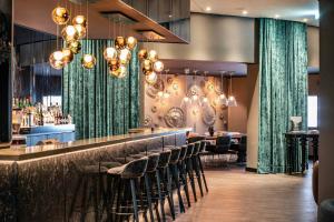 a bar with stools in a restaurant at Motel One Berlin-Ku'Damm in Berlin