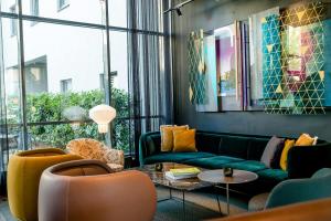 a living room with a couch and chairs and a table at Motel One Berlin-Hackescher Markt in Berlin
