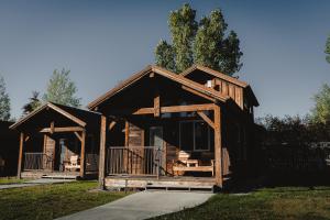 a log cabin with a porch at Teton Valley Resort in Victor