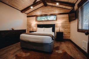 a bedroom with a large bed in a room with wooden walls at Teton Valley Resort in Victor +79 photos