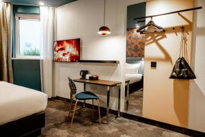 a hotel room with a desk and a bed at Motel One Edinburgh-Princes in Edinburgh