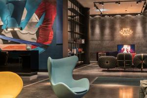 a living room with a chair and a tv at Motel One Berlin-Alexanderplatz in Berlin