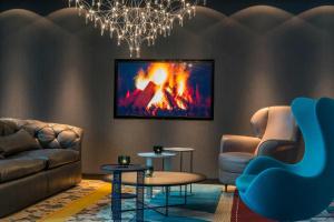 a living room with a couch and a fire on the wall at Motel One Berlin-Alexanderplatz in Berlin