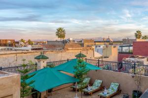 a view from a balcony with chairs and umbrellas at Riad Secret De Medina in Marrakesh