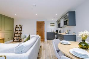 a living room with a white couch and a table at Rock Mill - The Penthouse Suite in Stony Middleton +37 photos
