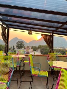 a patio with tables and chairs with a view of the mountains at Hotel-Posada Kali Tlayacapan in Tlayacapan