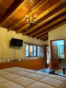 a large room with a large bed and a ceiling at Hotel-Posada Kali Tlayacapan in Tlayacapan