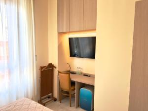 a hotel room with a desk with a television on the wall at Hotel Molise 2 in Milan