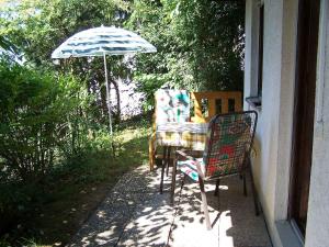 einen Tisch und Stühle auf einer Veranda mit Sonnenschirm in der Unterkunft Ferienwohnung Unterschütz in Ettenheim