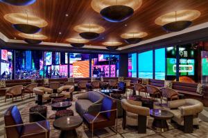 a bar with chairs and tables and windows at Renaissance New York Times Square by Marriott in New York