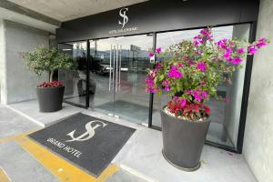 three large pots of flowers in front of a store at SJ Grand Hotel Monterrey in Monterrey